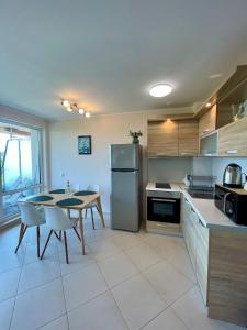 a kitchen with a table and a refrigerator at Byla Sea side Apartament in Byala