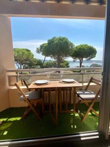 a table and chairs on a balcony with a view of the ocean at Le bleu de George Sand, hébergement de charme à Tamaris in La Seyne-sur-Mer