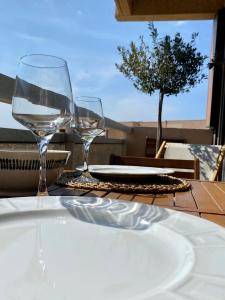 a table with two wine glasses and a plate on it at Le bleu de George Sand, vue mer exceptionnelle in La Seyne-sur-Mer