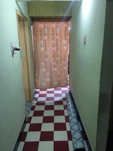 a hallway with a checkered floor and a curtain at Lively vibes ensured in Hyderabad