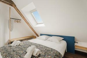 ポントルソンにあるLa Mer - Appartement calme et douillet à 5km du Mont St Miche - Wifi - Netflixの白いタオルが敷かれたベッドのある寝室