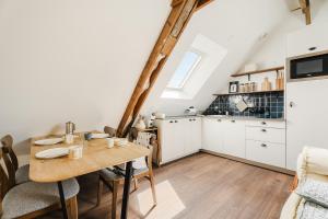 ポントルソンにあるLa Mer - Appartement calme et douillet à 5km du Mont St Miche - Wifi - Netflixの木製のテーブルとダイニングルームのあるキッチン