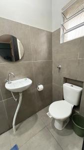 a bathroom with a toilet and a sink at Suíte 04 • Praia das Pitangueiras in Guarujá