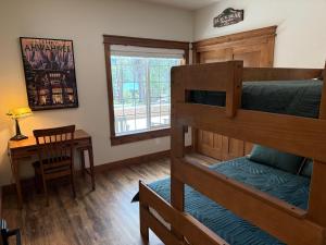 a bedroom with two bunk beds and a desk at 56 Black Bear Bungalow in North Wawona