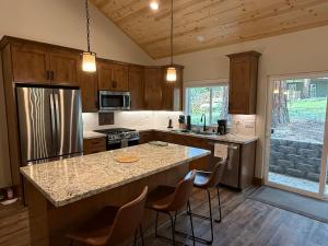 a kitchen with a large island with bar chairs at 56 Black Bear Bungalow in North Wawona
