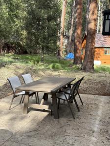 a wooden picnic table with two chairs around it at 56 Black Bear Bungalow in North Wawona