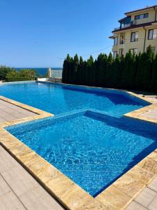 a large blue swimming pool next to a building at Byla Sea side Apartament in Byala