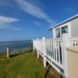 a white house with a view of the ocean at No 22 - Seaview Dream Retreatt in Newbiggin-by-the-Sea +2 photos