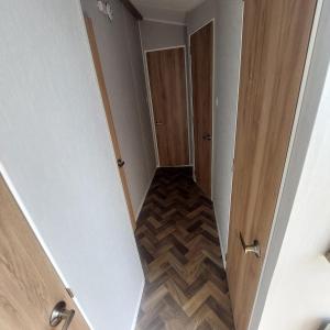 einen leeren Flur mit Tür und Holzboden in der Unterkunft No 22 - Seaview Dream Retreatt in Newbiggin-by-the-Sea