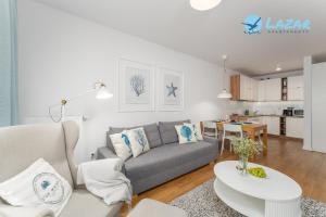 コウォブジェクにあるLazar Apartamenty Nadmorskie Tarasyのソファとテーブルのあるリビングルーム