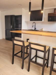 a kitchen with two bar stools and a counter at Llanesmar in Posada de Llanes +17 photos