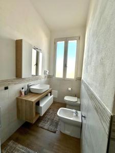 a bathroom with two sinks and a toilet and a mirror at Austinu e Bingedda's Home in Ardara +44 photos