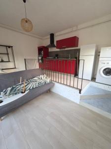 a kitchen with a couch and a washing machine at charmant t2 in Petreto-Bicchisano