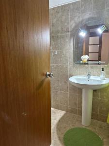 a bathroom with a sink and a wooden door at Azor International Apartment II in Ponta Delgada
