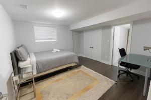 a bedroom with a bed and a desk and a table at Cozy 3BR Caledon Basement Suite with Private Access, Backyard Basketball Court, Full Kitchen, WiFi, Laundry, 5 Mins to Brampton, Family Friendly, Near Trails & Parks! in Caledon