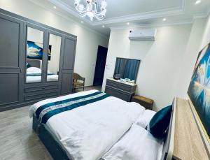 ein Schlafzimmer mit einem großen Bett und einem Kronleuchter in der Unterkunft Vista Mansion in New cairo