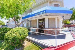 un bâtiment avec un auvent bleu en face d'un magasin dans l'établissement Motel 6-Mesa, AZ - South, à Mesa