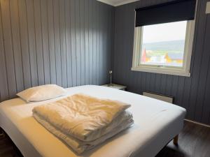 un letto con una coperta in una stanza con finestra di Berlevåg Motell AS a Berlevåg