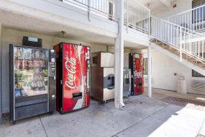 three cocacola machines are parked outside of a building at Motel 6-Mesa, AZ - South in Mesa