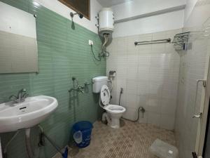 a bathroom with a sink and a toilet and a mirror at Oasis Guest House Bhagsu D'shala in Dharamshala