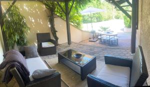 a living room with couches and a table and a patio at Le Moulin in Marlieux