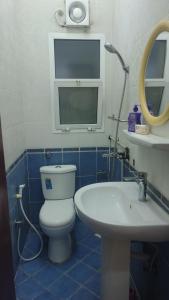 Un baño con inodoro, lavabo y espejo. en Muscat Galaxy Hostel, en Mascate 71 fotos más