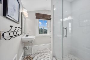 a white bathroom with a sink and a shower at 525 Route 28 Harwich Port Cape Cod - - The Mooring in Harwich Port +67 photos