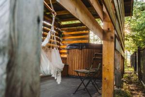 a hammock on the outside of a wooden pergola at Kalma Roztocze in Tereszpol Zaorenda