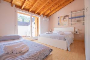 Un dormitorio con dos camas y una ventana. en Vista Lago - Casa Negroni, en Sale Marasino