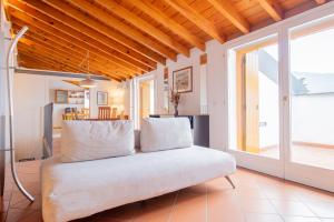 Una sala de estar con un sofá con almohadas. en Vista Lago - Casa Negroni, en Sale Marasino