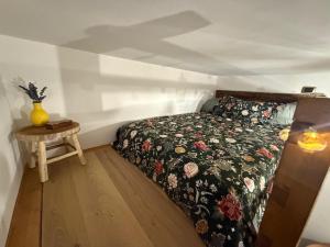 a bedroom with a bed with a floral bedspread and a table at Casa Carmela Cerasuolo Filignano in Filignano