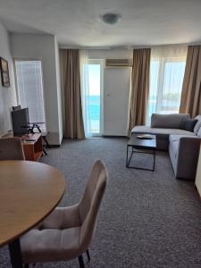 a living room with a couch and a table at Elite Family Hotel in Kiten