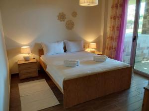 a bedroom with a large bed with two lamps at Villa Polyxeni Lavender 150m from the sea in Politiká