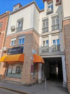 an apartment building with an orange awning on a street at Wesselényi Apartment in Kecskemét