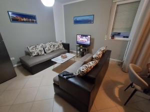 a living room with a couch and a tv at Perla Blu Albania in Durrës