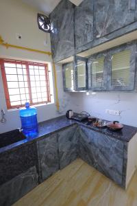 une cuisine avec un comptoir noir et quelques fenêtres dans l'établissement Newly built spacious and luxurious 2bhk with scenic hill views in tirupati, à Tirupati