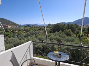 a table on a balcony with a cup of coffee at Angel's apartments in Panayía