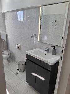 a bathroom with a sink and a toilet at Angel's apartments in Panayía +9 photos