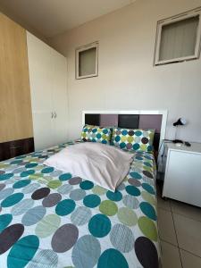 ein Schlafzimmer mit einem Bett mit einer bunten Bettdecke in der Unterkunft Durban Beach flats Marine Parade in Durban + 3 Fotos