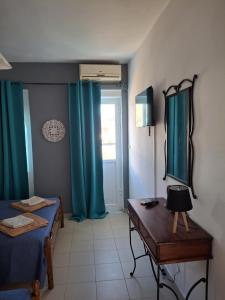 a room with a bed and a desk and a window at Angel's apartments in Panayía