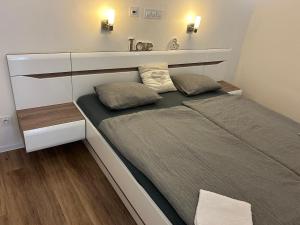 un letto in una piccola stanza con due cuscini sopra di Luxusní apartmán v centru Jihlavy a Jihlava