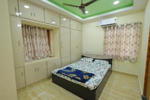 une chambre avec un lit et un ventilateur de plafond dans l'établissement Newly built spacious and luxurious 2bhk with scenic hill views in tirupati, à Tirupati