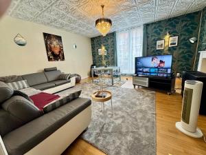 a living room with a couch and a flat screen tv at Royal Casino Namur Balcony in Namur