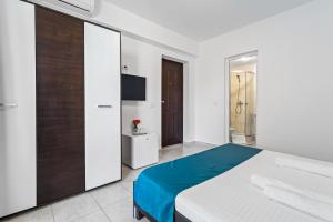 ein weißes Schlafzimmer mit einem Bett und einem Fernseher in der Unterkunft Vila Bella 2M in Costinești + 48 Fotos