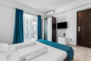 Schlafzimmer mit einem Bett mit blauen Vorhängen und einem TV in der Unterkunft Vila Bella 2M in Costinești