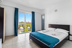 ein Schlafzimmer mit einem großen Bett und einem großen Fenster in der Unterkunft Vila Bella 2M in Costinești