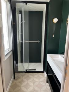 a bathroom with a glass shower and a sink at Mobil home 6 personnes à 400m de la mer in Argelès-sur-Mer