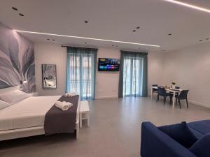 a bedroom with a bed and a dining room at Meraviglia B&B - Salerno Centro Close to the Station and Pier in Salerno