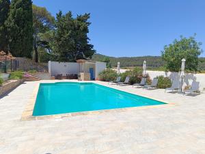 a swimming pool in a yard with chairs around it at Château de Prax Viel - piscine et mini ferme, climatisé in Lagrasse