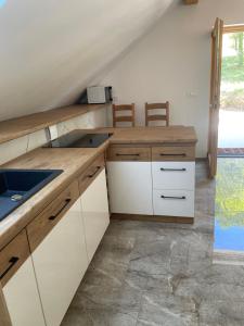 a kitchen with white cabinets and a sink at Zerko Holiday Apartment Janko with a private outdoor jacuzzi for FREE in Mirna